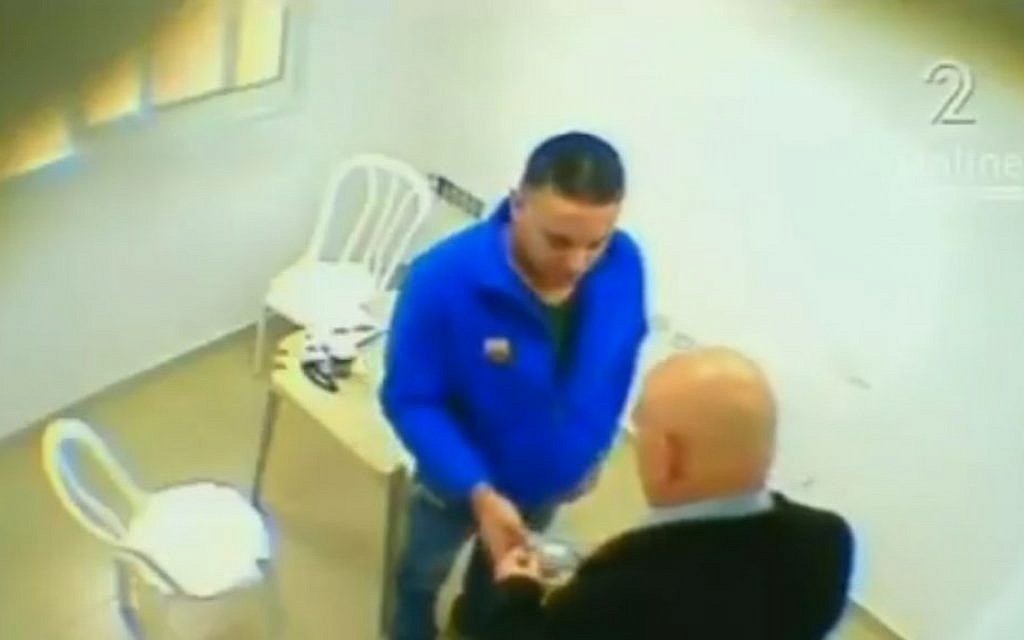 Footage appearing to show MK Basel Ghattas handing over a package to Palestinian prisoner Walid Daka (Screen capture: Channel 2)