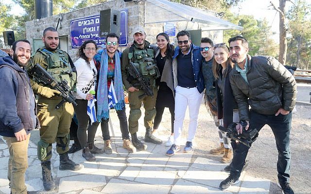 Joseph Waks, fourth from the right, posing with Jewish visitors and soldiers at the Oz Vegaon tent outpost in the West Bank, January 2, 2017. (Bobby Weitzner)