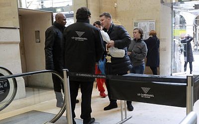 Tourists go through a security checkpoint as they enter the Carrousel du Louvre in Paris on February 4, 2017, a day after a machete-wielding attacker lunged at four French soldiers in a public area that leads to one of the Louvre Museum's entrances. (AFP/Jacques Demarthon)