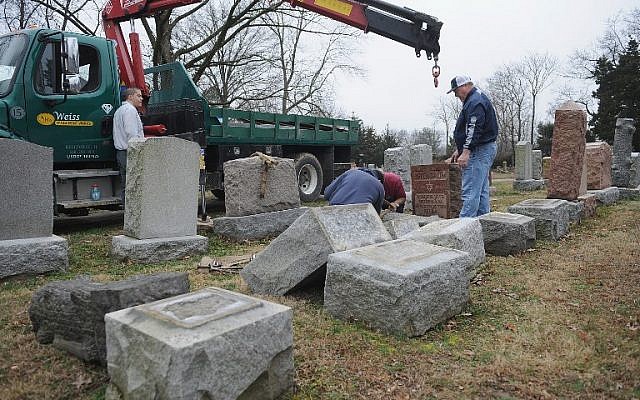 Volunteers from a local monument company help to reset vandalized headstones at Chesed Shel Emeth Cemetery on February 22, 2017 in University City, Missouri. (Michael Thomas/ Getty Images)