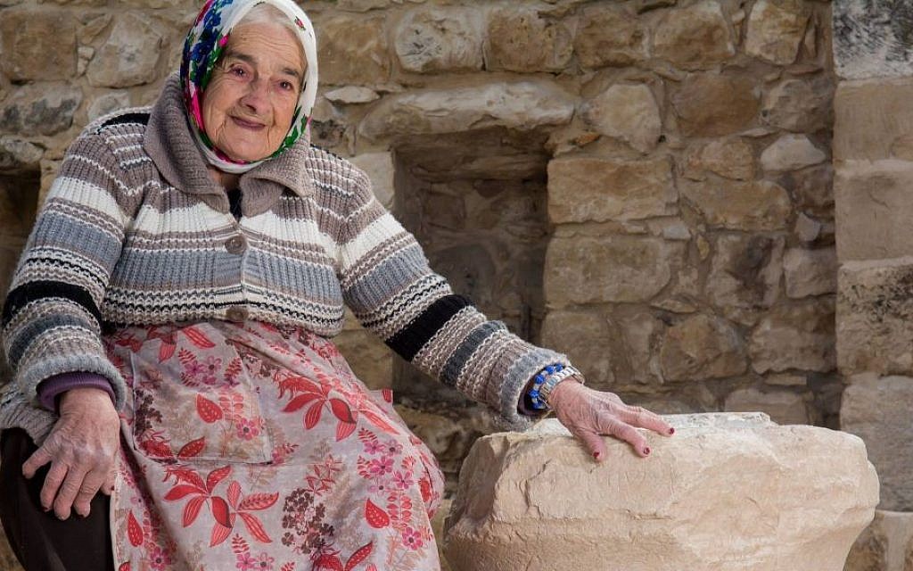 Margalit Zinati, sole Jewish resident of the Druze village of Peki'in in the Galilee, with an 1,800-year-old limestone capital bearing two Hebrew inscriptions found there in February 2017. (Ritvo courtesy of Beit Zinati)