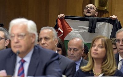 A protestor, holding a Palestinian flag, interrupts David Friedman, nominated to be US Ambassador to Israel, as he testifies on Capitol Hill in Washington, Thursday, Feb. 16, 2017, at his confirmation hearing before the Senate Foreign Relations Committee. (AP Photo/Susan Walsh)