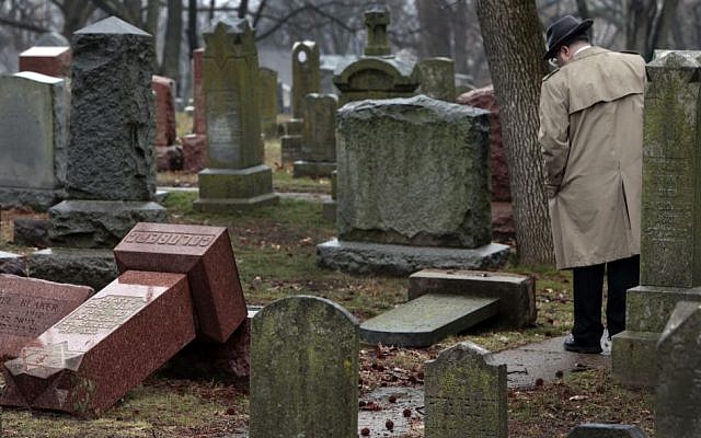 People walk through toppled graves at Chesed Shel Emeth Cemetery in University City, Missouri, on February 21, 2017. (Robert Cohen /St. Louis Post-Dispatch via AP)