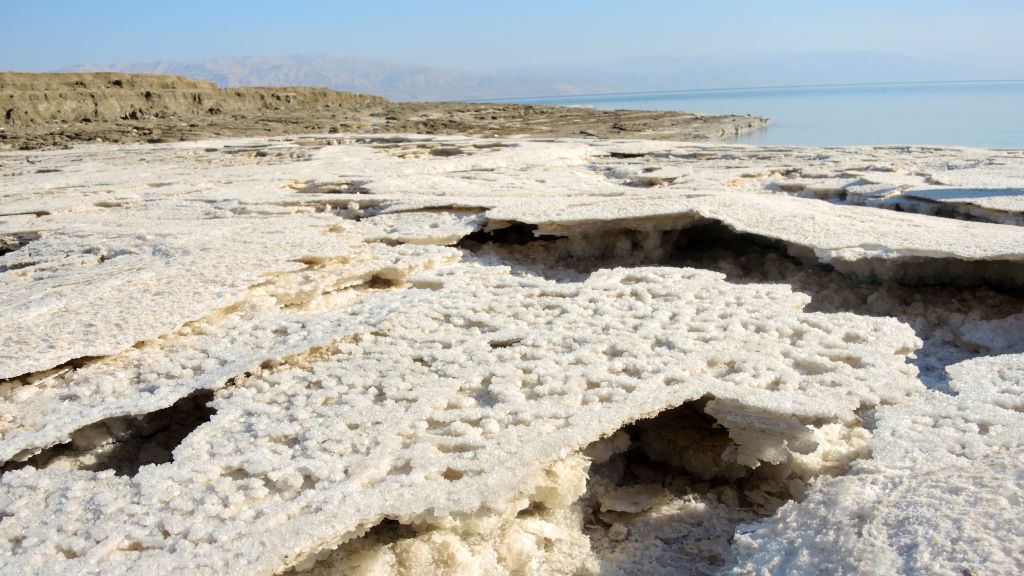The receding shore line leaves a thin crust of salt behind as the water level of the Dead Sea drops more than a meter a year, like this area pictured on January 11, 2017. (Melanie Lidman/Times of Israel)