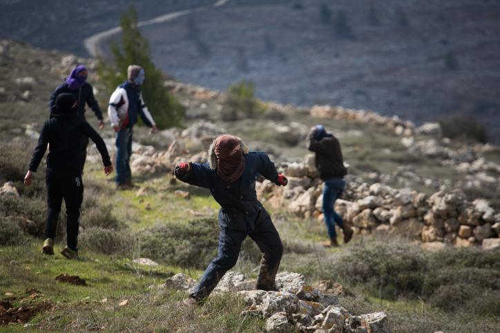 Young Jewish protesters throw rocks at police forces at the illegal outpost of Amona, on February 1, 2017, on the morning of the settlement's evacuation. (Hadas Parush/Flash90)