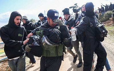 An Israeli policeman who refused to carry out the evacuation order is taken out during the evacuation of the illegal outpost of Amona, on February 1, 2017. (Hadas Parush/Flash90)