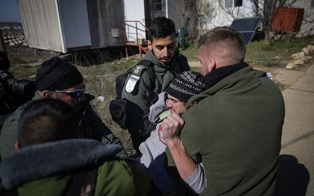 Illustrative. Israeli police forcibly evacuate a young man from the synagogue of the illegal outpost of Amona on February 2, 2017. (Yonatan Sindel/Flash90)