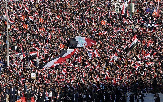 Followers of Iraq's influential Shiite cleric Muqtada al-Sadr chant slogans as they wave national flags during a demonstration against corruption in Baghdad, Iraq, Saturday, Feb. 11, 2017 (AP/Karim Kadim)
