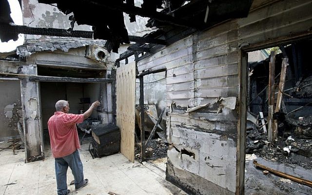 In a Thursday, Sept. 15, 2016, file photo, Farhad Khan, who has attended the Islamic Center of Fort Pierce for more than seven years, shows members of the media its charred remains, in Fort Pierce, Fla. (AP Photo/Wilfredo Lee, File)