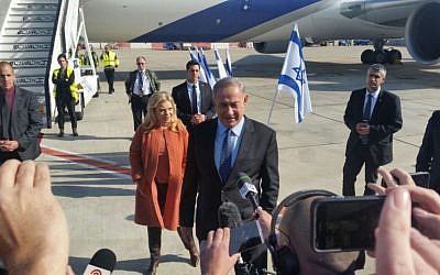Benjamin Netanyahu, with his wife Sara Netanyahu behind him, speaking to the press before boarding a plane to the US, at Ben-Gurion Airport, on February 13, 2017. (Raphael Ahren/Times of Israel)