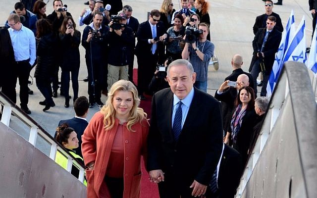 Benjamin Netanyahu, right, with his wife Sara Netanyahu, boarding a plane to the US, at Ben-Gurion Airport, on February 13, 2017. (Avi Ohayun/GPO)