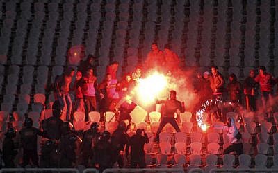 In this Feb. 1, 2012 file photo, Egyptian fans clash with riot police following an Al-Ahly club soccer match against Al-Masry club at the soccer stadium in Port Said, Egypt. (AP/File photo)