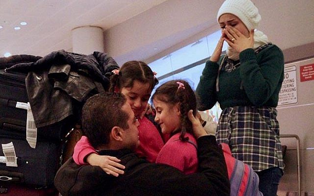 Fadi Kassar hugs his young daughters for the first time in over 2 years after his family was reunited at John F. Kennedy Airport in New York City, February 2, 2017. (Bill Swersey/HIAS)