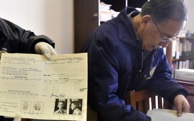 Edgar Ramirez right), the head of the archives in the Bolivian state mining company COMIBOL, with unearthed documents which reveal that Jewish-German tin baron Mauricio Hochschild helped thousands of Jews escape Nazism, in El Alto, Bolivia. (Aizar Raldes/AFP)