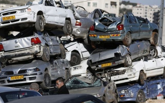 Wrecked cars with Israeli license plates are seen in the West Bank village of al-Ram on March 6, 2017. (AFP Photo/Abbas Momani)