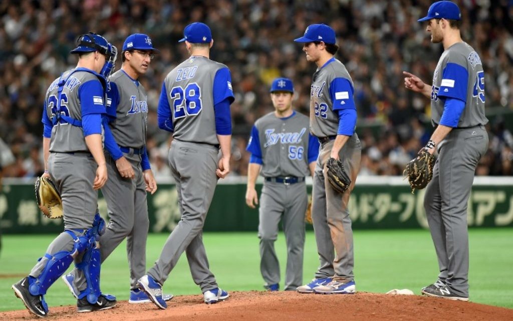Israeli infielders and a coach gather around picher Josh Zeid (#28) in the bottom of the third inning during the World Baseball Classic Pool E second round match between Israel and Japan at Tokyo Dome in Tokyo on March 15, 2017. (AFP PHOTO / TORU YAMANAKA)