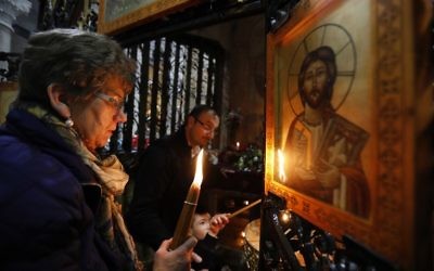 Christian worshippers light candles around the Edicule of the Tomb of Jesus (where his body is believed to have been laid) at the Church of the Holy Sepulchre in Jerusalem's Old City on March 21, 2017 (Gali Tibbon/AFP)
