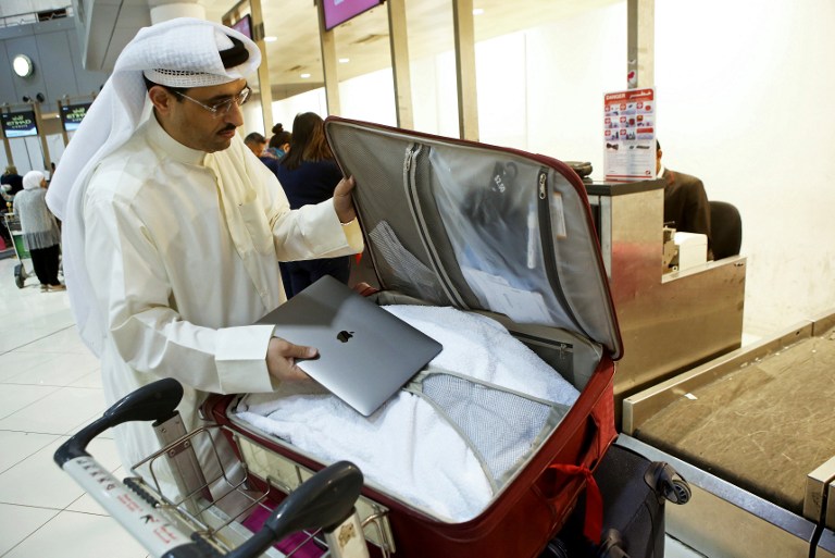 Kuwaiti social media activist Thamer al-Dakheel Bourashed puts his laptop inside his suitcase at Kuwait International Airport in Kuwait City, before boarding a flight to the United States on March 23, 2017. (AFP/Yasser Al-Zayyat)