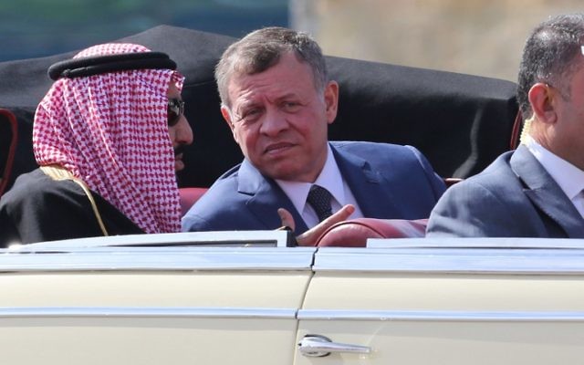Saudi Arabia's King Salman bin Abdulaziz al-Saud and Jordanian King Abdullah II sit in a vintage car during a welcome ceremony at the airport in the Jordanian capital Amman on March 27, 2017 ahead of the 28th Summit of the Arab League. / AFP PHOTO / Khalil MAZRAAWI