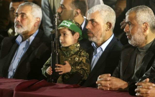 Hamas's new leader in the Gaza Strip Yahya Sinwar (2nd R) and senior political leader Ismail Haniyeh (L) sit next to the son of assassinated Hamas terrorist Mazen Faqha on March 27, 2017, in Gaza City. (AFP Photo/Mahmud Hams)