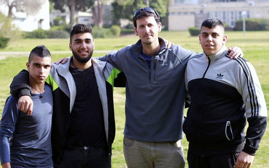 Anan Hujerat, left, Shadi Swaeed, center-left, and Mustafa Hujerat, right, participants of Israel's first army preparatory program geared towards Bedouin Israelis, pose with the head of the program, Tal Galin, center-right on their campus in Givat Haviva on February 27, 2017. (Judah Ari Gross/Times of Israel)