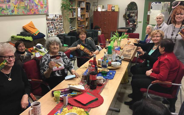 Seniors in Krakow, Poland enjoy Purim gift bags provided by Jewish Connection project delivered by Israeli travelers, March 2017. (Courtesy)