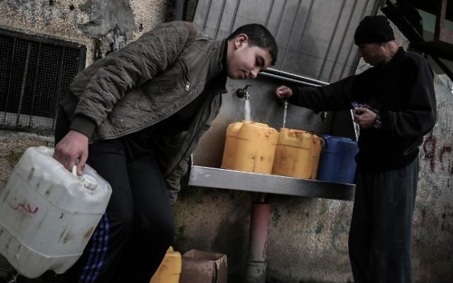Palestinians fill bottles and jerrycans with drinking water from public taps at the Rafah refugee camp in southern Gaza Strip, on February 22, 2017. (Said Khatib/AFP)