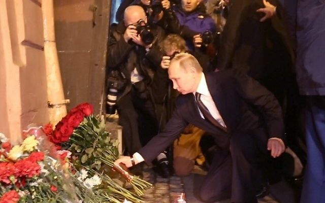 Russian President Vladimir Putin places flowers in memory of victims of the blast in the Saint Petersburg metro outside Technological Institute station on April 3, 2017. (AFP Photo/STR)