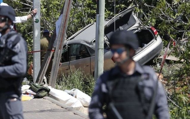 Israeli security forces inspect the site of a car ramming attack outside the Israeli West Bank Settlement of Ofra on April 6, 2017. (AFP Photo/Thomas Coex)