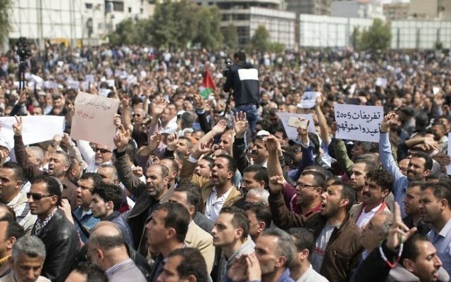Palestinian Authority employees chant slogans and wave placards during a demonstration against the decision by the PA to reduce their salaries in Gaza City on April 8, 2017. (AFP Photo/Mahmud Hams)