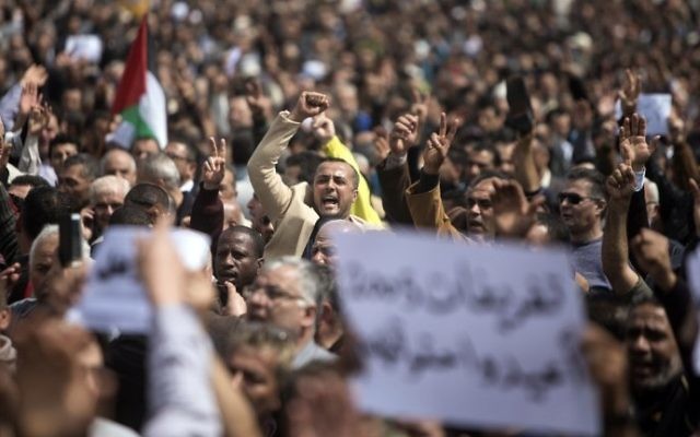 Palestinian Authority employees chant slogans and wave placards during a demonstration against the decision by the PA to reduce their salaries in Gaza City on April 8, 2017. (AFP Photo/Mahmud Hams) 