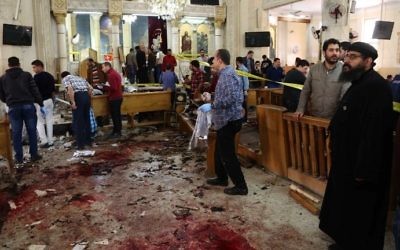 A general view shows people looking at the aftermath following a bomb blast which struck worshippers gathering to celebrate Palm Sunday at the Mar Girgis Coptic Church in the Nile Delta City of Tanta, north of Cairo, on April 9, 2017. (AFP Photo/Stringer)