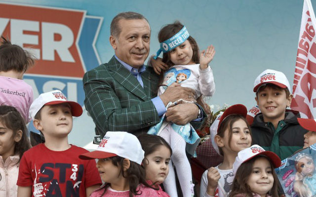 Turkish President Recep Tayyip Erdogan poses with children after a rally on April 15, 2017, in Istanbul on the eve of the constitutional referendum. (Ozan Kose/AFP)