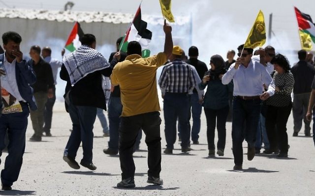 Palestinian protesters wave Palestinian flags and portraits of Marwan Barghouti in front of Ofer Prison in the West Bank village of Betunia on April 20, 2017. (AFP Photo/Abbas Momani)