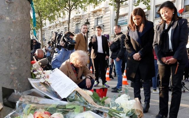 Mayor of Paris Anne Hidalgo (2R) and the Mayor of the 8th arrondissement of Paris Jeanne D'hauteserre (R) stand as they pay their respect at the site of a shooting on the Champs-Elysees in Paris on April 21, 2017, a day after a gunman opened fire on police along the avenue, killing a policeman and wounding two others. (AFP/Francois Guillot)