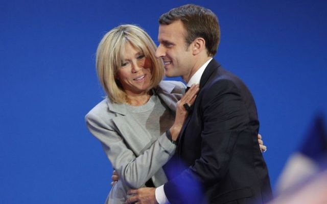 French centrist presidential candidate Emmanuel Macron and his wife Brigitte hug as he addresses his supporters at his election day headquarters in Paris , Sunday April 23, 2017. (AP/Christophe Ena)