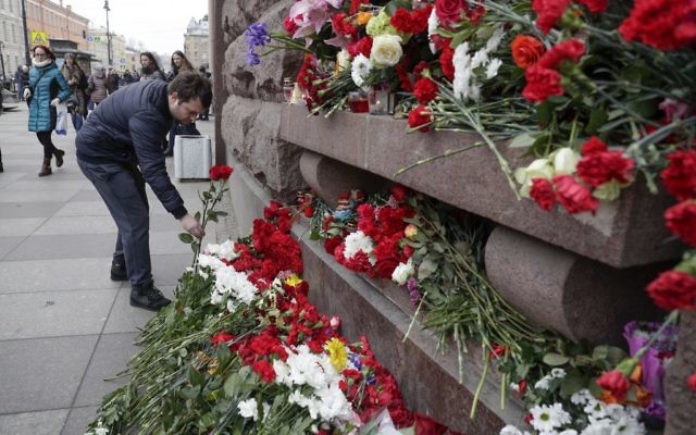 A man lays flowers at a symbolic memorial outside the Tekhnologichesky Institute subway station in St. Petersburg, Russia, April 4, 2017. (AP/Dmitri Lovetsky)