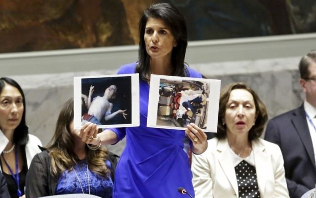 US Ambassador to the UN Nikki Haley shows pictures of Syrian victims of chemical attacks as she addresses a meeting of the Security Council on Syria at UN headquarters on April 5, 2017. (AP Photo/Bebeto Matthews)