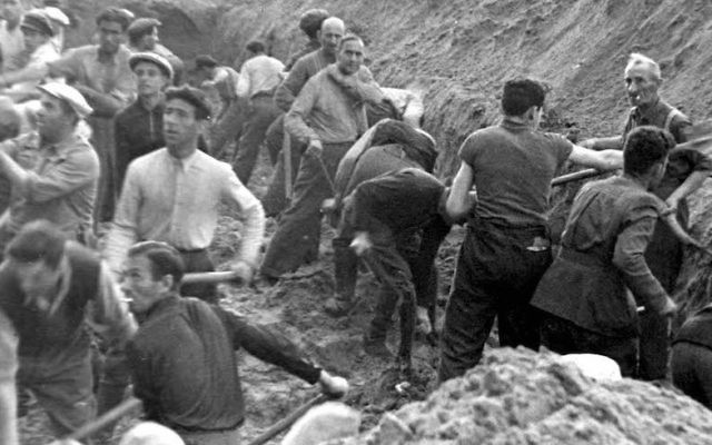 Illustrative: Jews digging a trench in which they were later buried after being shot, in Ponary, Poland. (Courtesy of Yad Vashem)