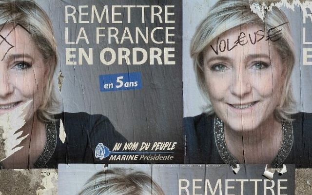 A picture taken on April 28, 2017 in Cessales near Toulouse, southern France shows campaign posters of French presidential election candidate Marine Le Pen, ahead of the final round of the presidential election on May 7. The posters show a swastika on one and the word 'thief' across Le Pen's forehead on the other. (AFP/ Eric CABANIS)
