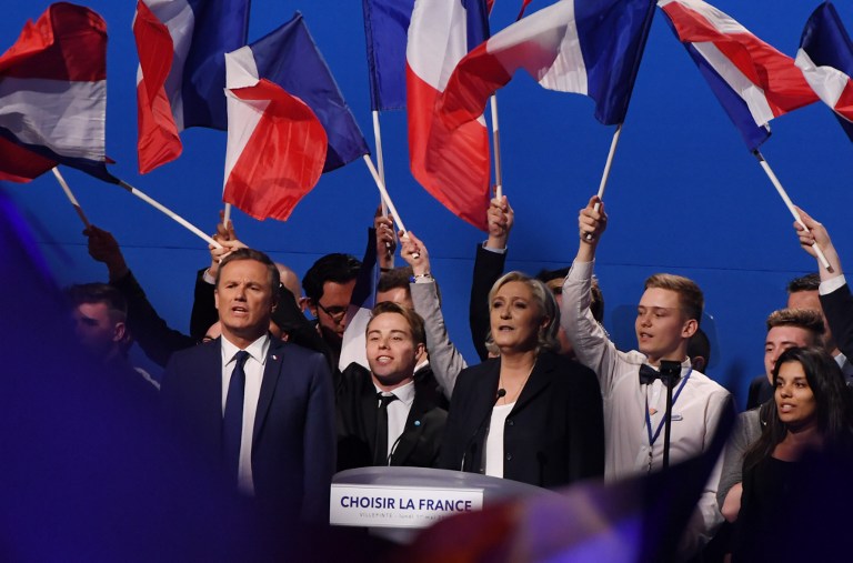 French presidential election candidate for the far-right Front National (FN) party Marine Le Pen (C), flanked by former French presidential election candidate for the right-wing Debout la France (DLF) party Nicolas Dupont-Aignan (L), gestures at the end of her meeting at the Parc des Expositions in Villepinte, on May 1, 2017. (AFP/Alain Jocard)