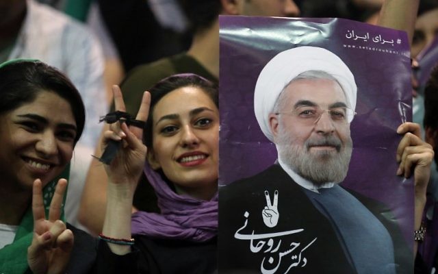 Supporters of Iranian presidential candidate Hassan Rouhani hold his portrait during a campaign rally in the capital Tehran on May 4, 2017. (AFP PHOTO / ATTA KENARE)