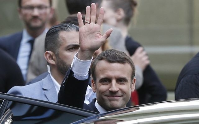 French President-elect Emmanuel Macron (C) gestures as he leaves an event for La Republique En Marche party candidates at the entrance of the Quai Branly museum on May 13, 2017, in Paris. (AFP Photo/Charly Triballeau)