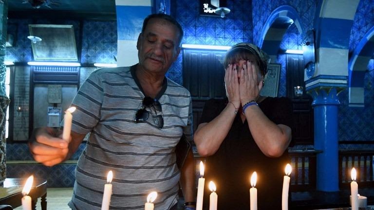 A Tunisian Jewish family lights candles at the Ghriba Synagogue on the Tunisian resort island of Djerba on May 14, 2017 during the second day of the annual Jewish pilgrimage to the synagogue thought to be Africa's oldest. (FETHI BELAID / AFP)