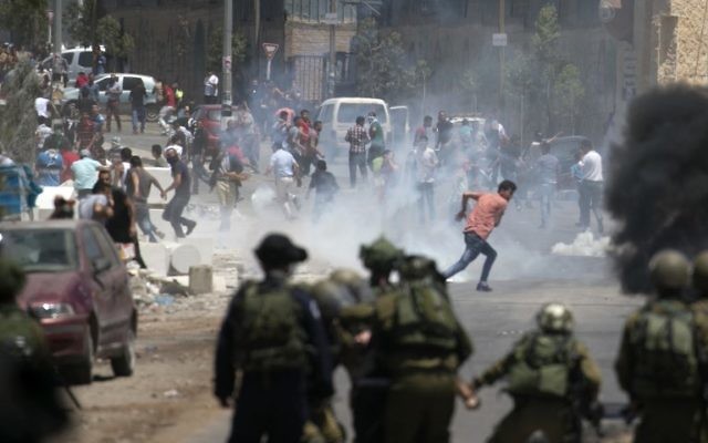 Israeli security forces clash with Palestinian demonstrators during a violent protest in solidarity with Palestinian prisoners outside Nablus on May 26, 2017. (Jaafar Ashtiyeh/AFP)