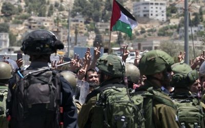 Palestinians take part in a violent protest in front of Israeli security forces following a Friday afternoon prayer service in solidarity with Palestinian security prisoners outside Nablus on May 26, 2017. (Jaafar Ashtiyeh/AFP PHOTO)