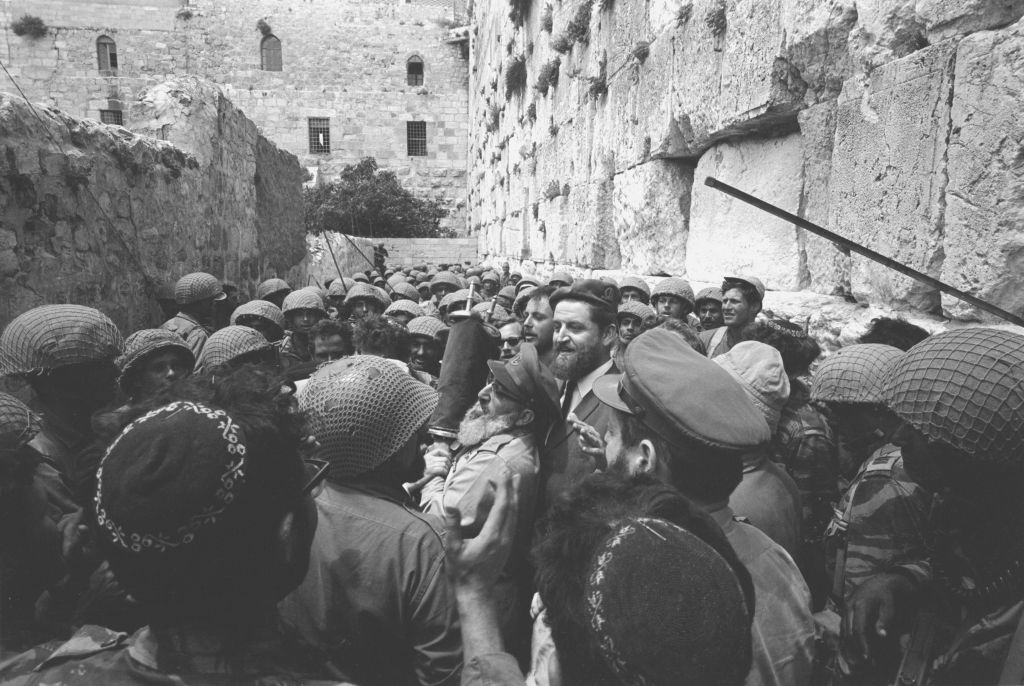 A group of paratroopers surrounds then-IDF chief rabbi Shlomo Goren at the Western Wall on June 7, 1967. (Micha Bar-Am/Defense Ministry's IDF Archive)