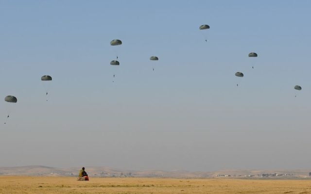 Paratroopers make their way down to earth during a parachuting exercise in central Israel on February 19, 2014. (IDF Spokesperson's Unit/Flickr)