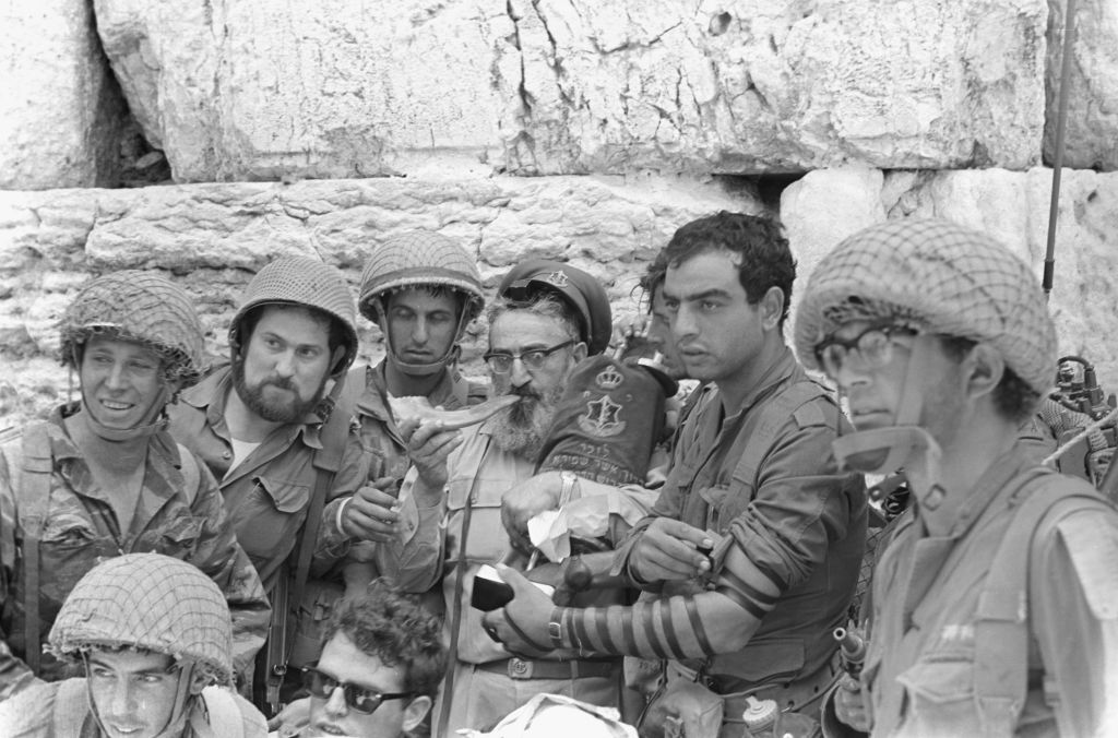 A group of soldiers surrounds then-IDF chief rabbi Shlomo Goren as he blows a shofar at the Western Wall in Jerusalem's Old City on June 7, 1967. (Bamahane Magazine/Defense Ministry's IDF Archive)