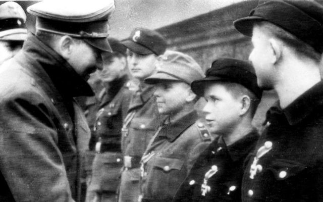 Adolf Hitler, left, shakes hands with 12-year-old Alfred Czech, a Hitler Youth soldier, after the young veteran of battles in Pomerania and Upper and Lower Silesia was awarded the Iron Cross at Hitler's headquarters in Germany on March 19, 1945, according to the German caption that accompanied the photo, taken by a Nazi photographer. The image is the last photo AP has of Hitler before his suicide a few weeks later. The photo was distributed by Buro Laux, a German Foreign Ministry conduit for photos, and transmitted to The Associated Press via the photo agency Pressens Bild in neutral Sweden. (Buro Laux/Pressens Bild via AP)